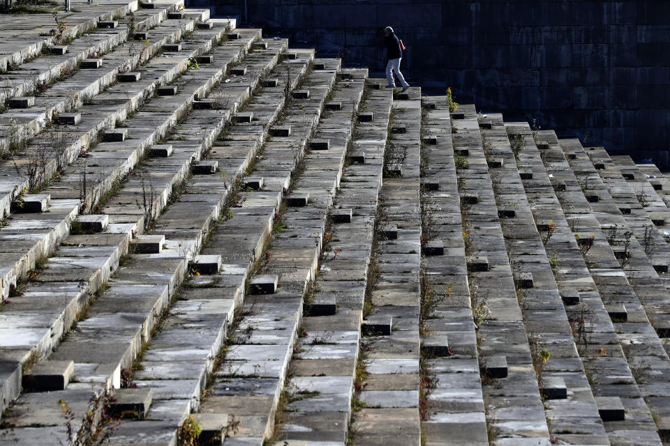 A woman climbs up stairs at the 'Zeppelinfeld' besides the main tribune of the 'Reichsparteigelande' (Nazi Party Rally Grounds) in Nuremberg, Germany, Wednesday, Nov. 18, 2020. Germany marks the 75th anniversary of the landmark Nuremberg trials of several Nazi leaders and in what is now seen as the birthplace of a new era of international law on Friday, Nov. 20, 2020. (AP Photo/Matthias Schrader)