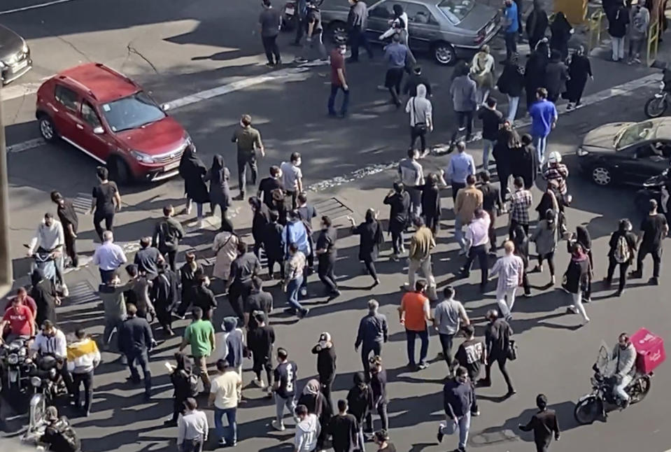 FILE - In this frame grab from video taken by an individual not employed by the Associated Press and obtained by the AP outside Iran shows people blocking an intersection during a protest to mark 40 days since the death in custody of 22-year-old Mahsa Amini, whose tragedy sparked Iran's biggest antigovernment movement in over a decade, in Tehran, Iran, Wednesday, Oct. 26, 2022. Belgium is urging its nationals to leave Iran and warns that they face the risk of arrest, arbitrary detention or unfair trial. The warning came after a detained Belgian aid worker was reportedly sentenced to 28 years in prison there last week. (AP Photo, File)