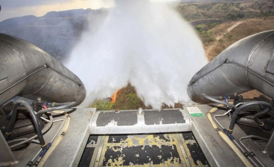 In this photo released by Brazil Ministry of Defense, a C-130 Hercules aircraft dumps water to fight fires raging in Brazil's Amazon, Saturday, Aug, 24, 2019. Backed by military aircraft, Brazilian troops on Saturday were deploying in the Amazon to fight fires that have swept the region and prompted anti-government protests as well as an international outcry. (Brazil Ministry of Defense via AP)