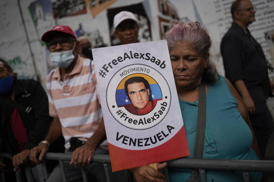 FILE - A woman holds a poster showing Colombian-born businessman Alex Saab during a demonstration demanding his release, in Caracas, Venezuela, Friday, Dec. 16, 2022. The U.S. Justice Department is prosecuting Saab for alleged money laundering. (AP Photo/Matias Delacroix, File)