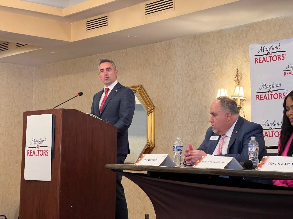 In this file photo, at lectern, Maryland Housing and Community Development Secretary Jake Day speaks during a news conference hosted by the trade association Maryland REALTORS on Feb. 14, 2024 in Annapolis as the organization's 2024 president and president-elect listen from the podium.