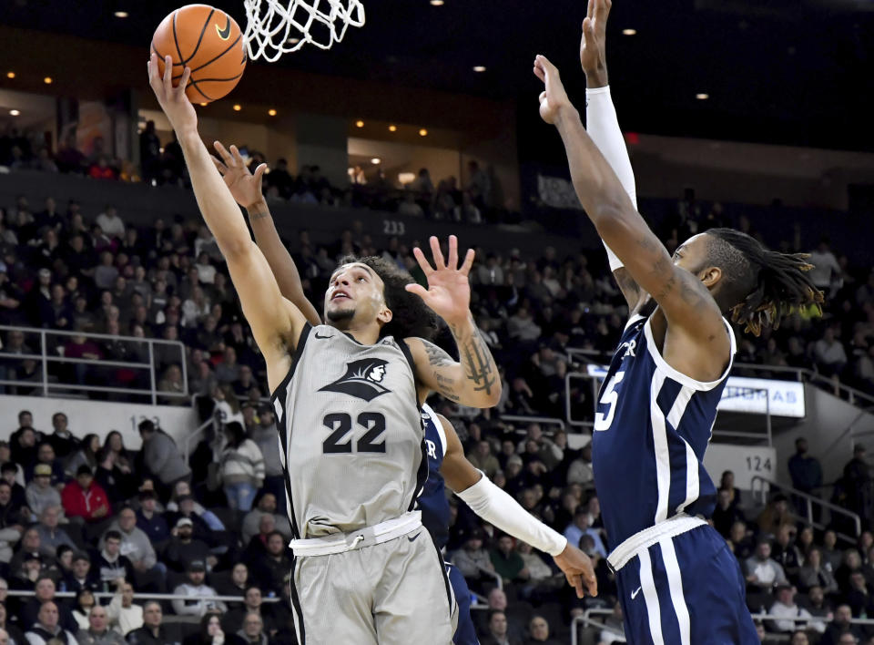 Providence's Devin Carter (22) scores on a layup during the first half of an NCAA college basketball game, Wednesday, Jan. 25, 2023, in Providence, R.I. At right is Butler's Manny Bates. (AP Photo/Mark Stockwell)