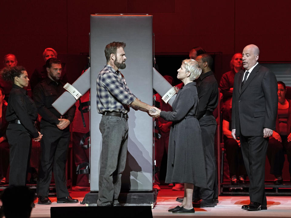 This image released by the Metropolitan Opera shows Ryan McKinny as Joseph De Rocher, foreground left, Joyce DiDonato as Sister Helen Prejean, foreground center, and Raymond Aceto as George Benton in Jake Heggie's "Dead Man Walking" on Sept. 15, in New York. (Karen Almond/Met Opera via AP)