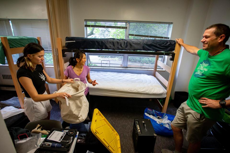 Parents Gladys, center, and Ben Feick, right, help move their daughter Cruz into her dorm Thursday at the University of Oregon during move-in day.