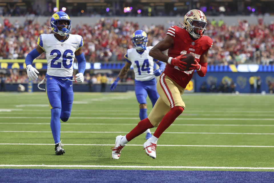 San Francisco 49ers wide receiver Jauan Jennings, right, scores a touchdown past Los Angeles Rams safety Kamren Kinchens (26) and cornerback Cobie Durant (14) during the second half of an NFL football game, Sunday, Sept. 22, 2024, in Inglewood, Calif. (AP Photo/Ryan Sun)