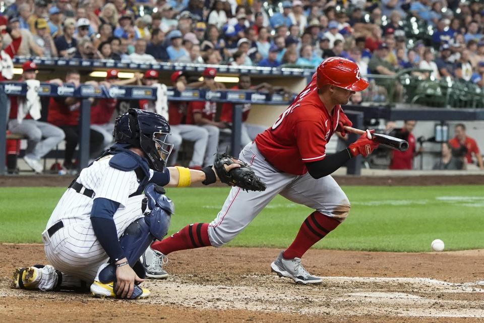 Cincinnati Reds' Nick Senzel bunts for a single during the ninth inning of a baseball game against the Milwaukee Brewers Sunday, Aug. 7, 2022, in Milwaukee. (AP Photo/Morry Gash)