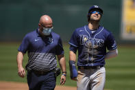 Tampa Bay Rays' Kevin Kiermaier, right, walks with a trainer back to the dugout after suffering an injury while stealing second base during the second inning of a baseball game against the Oakland Athletics, Saturday, May 8, 2021, in Oakland, Calif. (AP Photo/Tony Avelar)