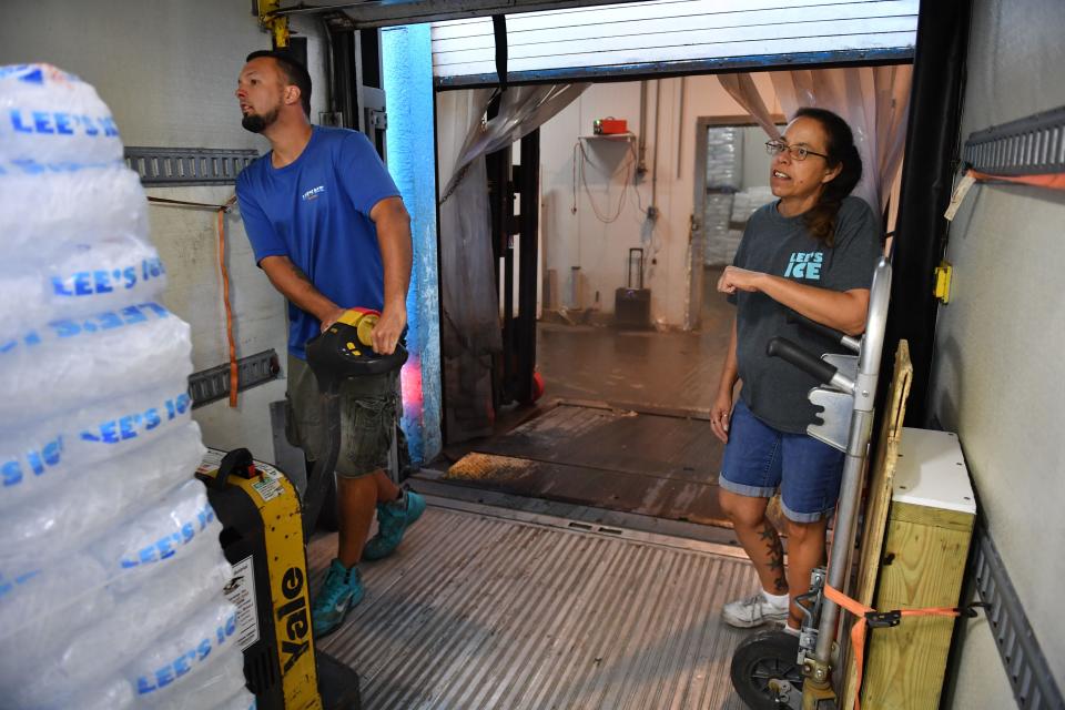 Daulton Berg, left, a commercial driver for Lee’s Food Mart and Ice in Sarasota, loads a pallet of ice into a delivery truck in the early morning of April 28. Manager Peggy Naughton, right, has been trying to hire a delivery driver for the past three months. She has five delivery trucks, but only four drivers.