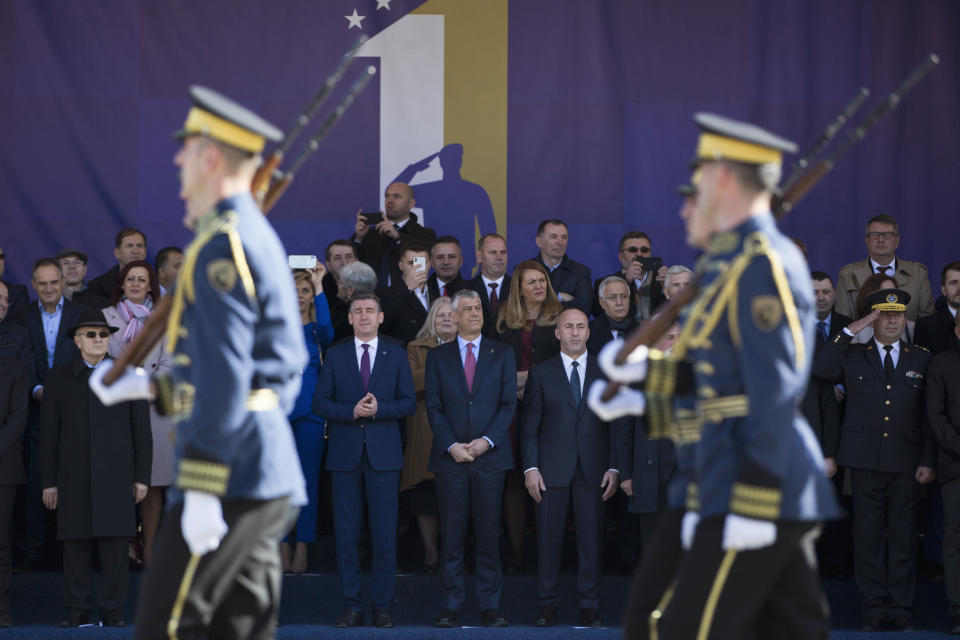 Kosovo president Hashim Thaci, center, watches the Kosovo Security Force members parade, during celebrations to mark the 11th anniversary of independence in Pristina, Sunday, Feb. 17, 2019. Thousands of civilians filled downtown Pristina Sunday decorated with national and U.S. flags while infantry troops with light weaponry of the Kosovo Security Forces, now transformed into a regular army, paraded as a “professional, multiethnic army serving the youngest country in the world,” as President Hashim Thaci said. (AP Photo/Visar Kryeziu)