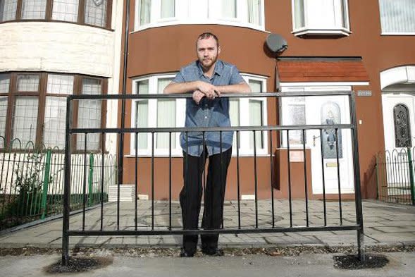 Adam Storey by the barrier outside his home.