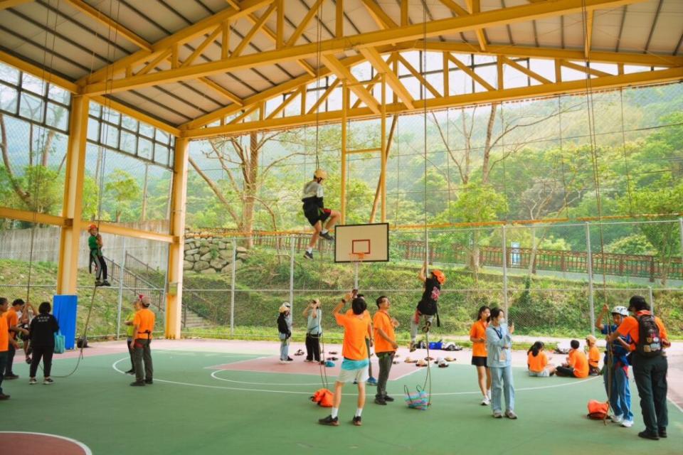 國小五年級學生小華成功挑戰了一項特別的高難度活動：高空爬繩，這是小華第一次參加露營活動，面對近兩層樓高的挑戰，在專業人員的引導下順利完成。(圖片提供：諾美締)