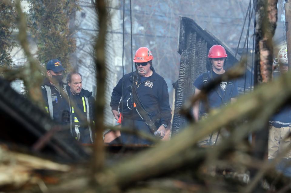 Firefighters work at the scene of the March 23 fire at the Evergreen Court Home for Adults in Spring Valley.