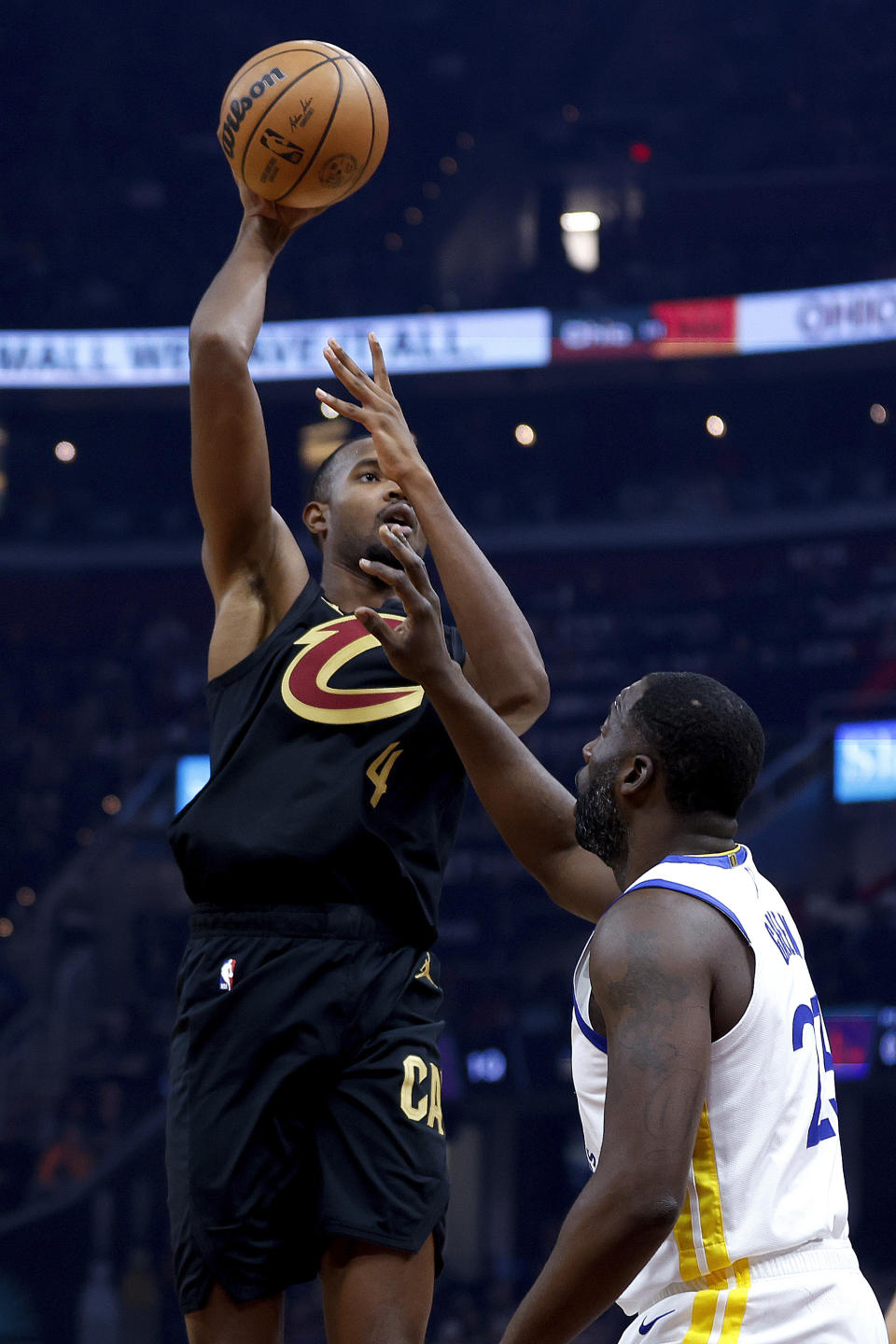 Cleveland Cavaliers forward Evan Mobley (4) shoots against Golden State Warriors forward Draymond Green, right, during the first half of an NBA basketball game, Sunday, Nov. 5, 2023, in Cleveland. (AP Photo/Ron Schwane)