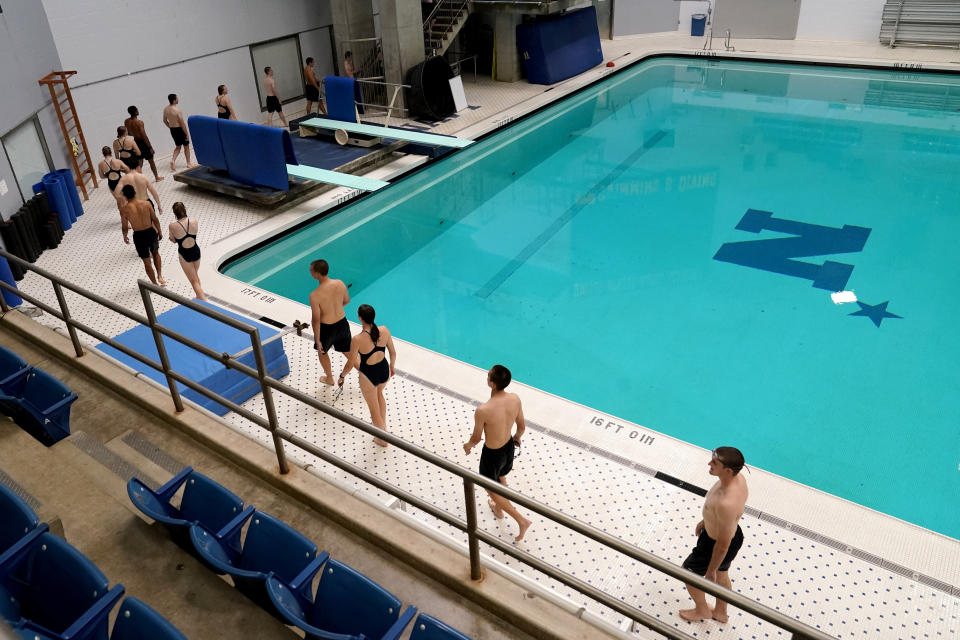 Midshipmen walk in a line as they make their way to the five-meter platform to dive onto a pool at the end of a swim class at the U.S. Naval Academy, Monday, Aug. 24, 2020, in Annapolis, Md. Under the siege of the coronavirus pandemic, classes have begun at the Naval Academy, the Air Force Academy and the U.S. Military Academy at West Point. But unlike at many colleges around the country, most students are on campus and many will attend classes in person. (AP Photo/Julio Cortez)