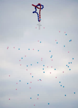 Balloons are released during a funeral service for six members of the Holcombe family and 3 members of the Hill family, victims of the Sutherland Springs Baptist church shooting, in Sutherland Springs, Texas, U.S. November 15, 2017. REUTERS/Darren Abate