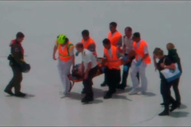 <p>United States Coast Guard</p> Coast Guard members carry the patient on a stretcher