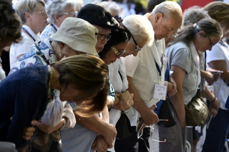 Catholic pilgrims pray during Assumption celebrations in the French southwestern city of Lourdes, on August 15, 2016
