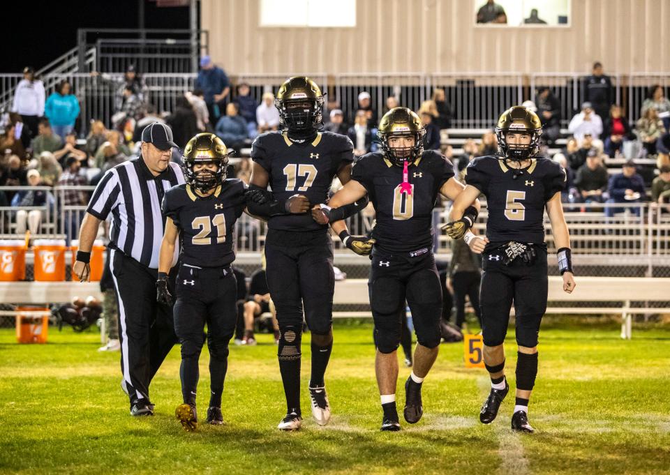 Xavier Prep captains Tyson Ruiz (21), Kyle Hill (17), Jesus Pazos (0) and Braden Cervello (5) walk out for the coin toss before their second-round playoff game at Xavier College Preparatory High School in Palm Desert, Calif., Friday, Nov. 10, 2023.