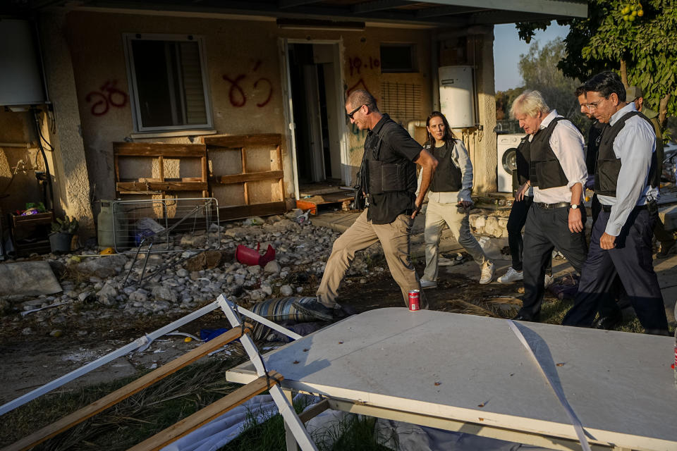 Former UK Prime Minister Boris Johnson, second right visits kibbutz Kfar Azza, Israel, Sunday, Nov. 5, 2023. Kibbutz Kfar Azza was one of the locations attacked by Hamas on Oct. 7. (AP Photo/Ariel Schalit)