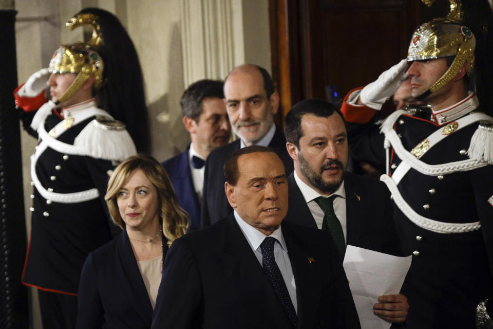 FILE - Forza Italia Leader Silvio Berlusconi, center, walks with Brothers of Italy party's leader Giorgia Meloni, left, and the League leader Matteo Salvini to meet journalists at the Quirinale presidential palace after talks with Italian President Sergio Mattarella, in Rome, Thursday, April 12, 2018. As a young teen, Italy's Giorgia Meloni embarked on an ideological quest that has propelled her to the verge of government power. The Sept. 25 election victory of her Brothers of Italy, a party with neo-fascist roots that she helped establish a decade ago, provided Meloni with a springboard into the Italian premiership.r. (AP Photo/Gregorio Borgia, File)