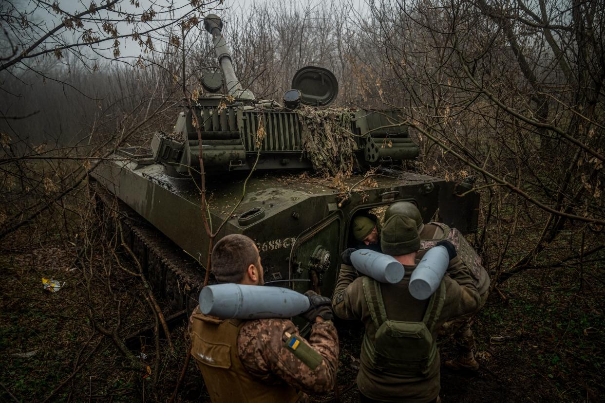 Ukrainian artillerymen load ammunition onto a tank.