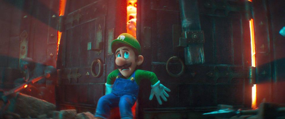 Luigi in The Super Mario Bros. Movie holding back the doors to the creepy mansion.