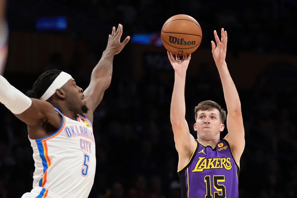 Los Angeles Lakers guard Austin Reaves, right, shoots as Oklahoma City Thunder guard Luguentz Dort defends during the first half of an NBA basketball game Friday, March 24, 2023, in Los Angeles. (AP Photo/Mark J. Terrill)