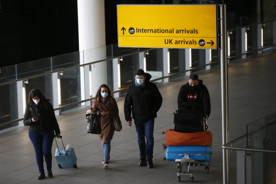 LONDON, ENGLAND - JANUARY 17: Travelers arrive at Heathrow Airport on January 17, 2021 in London, England. Tomorrow morning the UK will close its so-called "travel corridors" with countries from which arriving travelers were exempt from quarantine requirements. People flying into the UK will now be required to quarantine for 10 days unless they test negative for covid-19 after five days, or unless they qualify for a business-travel exemption. (Photo by Hollie Adams/Getty Images)