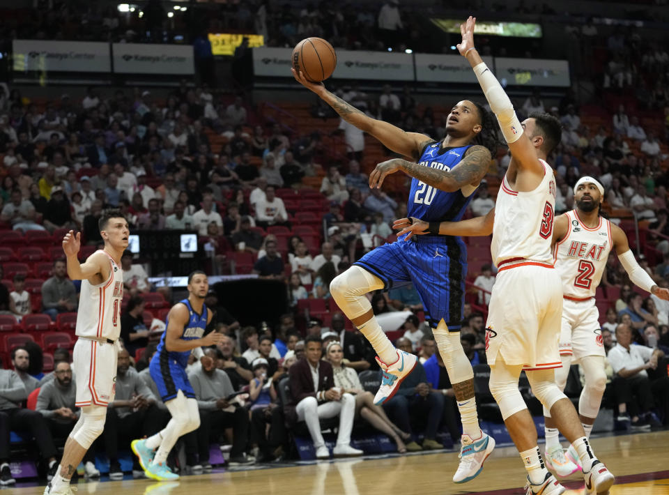 Orlando Magic guard Markelle Fultz (20) goes to the basket as Miami Heat guard Max Strus defends during the first half of an NBA basketball game, Sunday, April 9, 2023, in Miami. (AP Photo/Lynne Sladky)