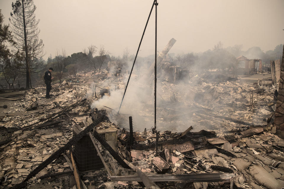 A police officer looks over the destruction of a home in Santa Rosa.&nbsp;