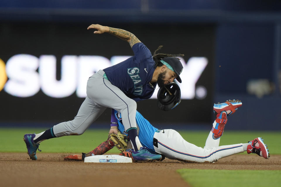 Seattle Mariners shortstop J.P. Crawford, left, is unable to tag Miami Marlins' Jazz Chisholm Jr. after Chisholm hit a double during the first inning of a baseball game, Sunday, June 23, 2024, in Miami. (AP Photo/Wilfredo Lee)