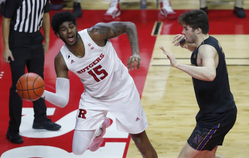 Rutgers center Myles Johnson (15) keeps the ball in play against Northwestern center Ryan Young, right, during the second half of an NCAA college basketball game in Piscataway, N.J., Saturday, Feb. 13, 2021. (AP Photo/Noah K. Murray)
