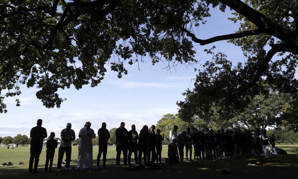 In this Saturday, March 23, 2019, file photo, Muslim men pray at Hagley Park across a road from the Al Noor mosque following the March 15 mass shooting in Christchurch, New Zealand. (AP Photo/Mark Baker, File)