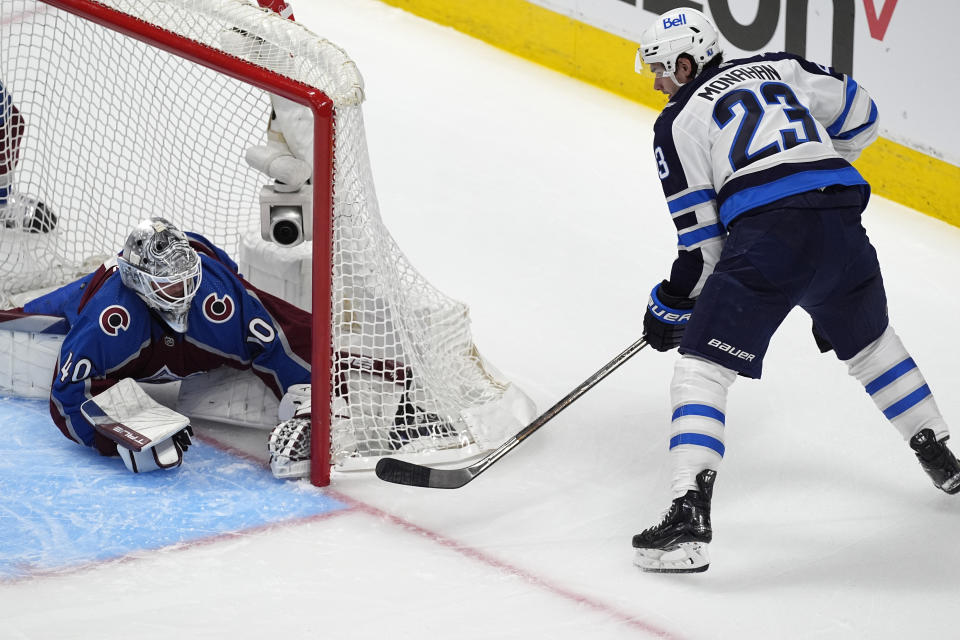 Colorado Avalanche goaltender Alexandar Georgiev, left, stops a wraparound shot by Winnipeg Jets center Sean Monahan during the first period of Game 3 of an NHL hockey Stanley Cup first-round playoff series Friday, April 26, 2024, in Denver. (AP Photo/David Zalubowski)