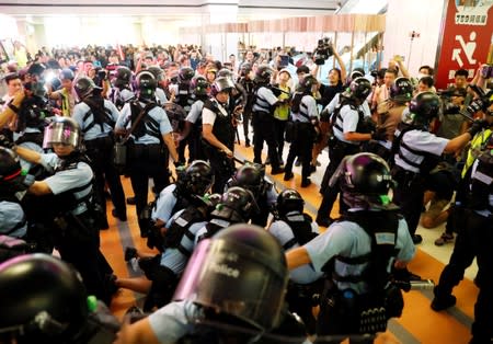 A protester is detained by the police officers at Amoy Plaza shopping mall in Kowloon Bay, Hong Kong