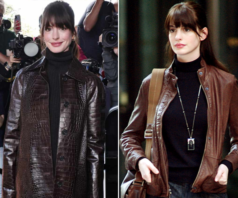 Anne Hathaway wears a black turtle neck underneath a brown leather jacket in front of paparazzi