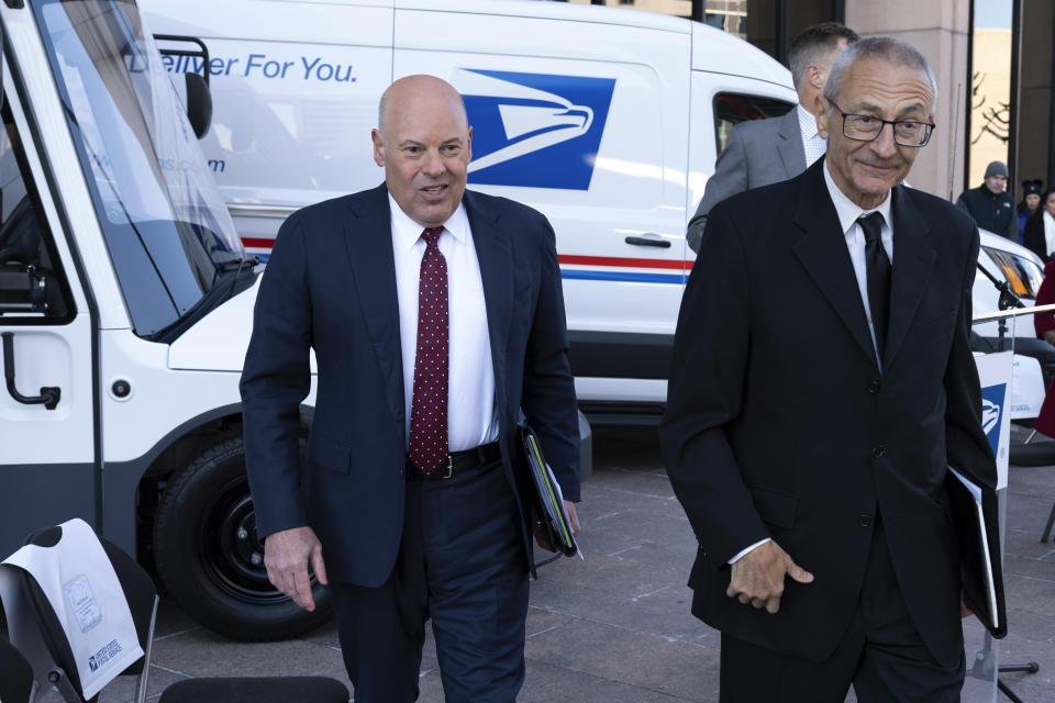 Postmaster General of the United States of America Louis DeJoy, left, accompanied by Senior Advisor to the President for Clean Energy Innovation and Implementation John Podesta, leave after a news conference announcing the Postal Service will sharply increase the number of electric-powered delivery trucks in its fleet and will go all-electric for new purchases starting in 2026. (AP Photo/Jose Luis Magana)