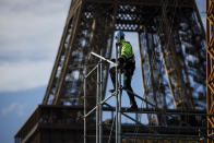 A workers builds the stands for the upcoming summer Olympic Games on the Champ-de-Mars just beside the Eiffel Tower, in Paris, Monday, April 1, 2024 in Paris. The Paris 2024 Olympic Games will run from July 26 to Aug.11, 2024. (AP Photo/Thomas Padilla)