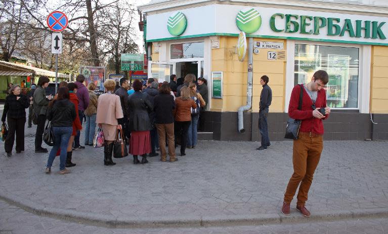 People wait for their turn to enter a local branch of the Russian Sberbank in the Crimean capital of Simferopol on April 7, 2014