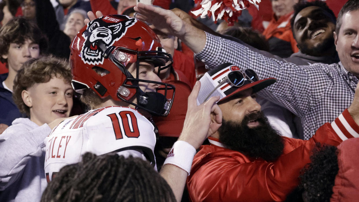 North Carolina State quarterback Ben Finley (10) celebrates with fans after the team defeated North Carolina in overtime in an NCAA college football game Friday, Nov. 25, 2022, in Chapel Hill, N.C. (AP Photo/Chris Seward)