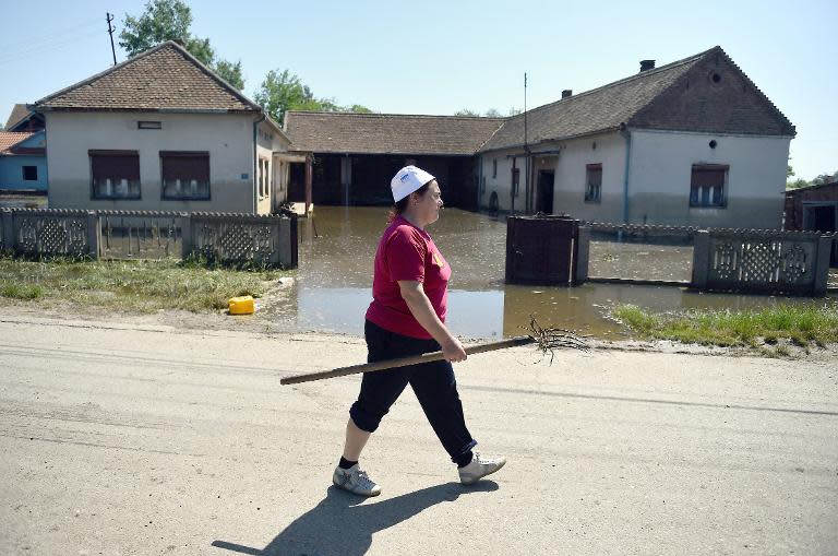 A woman walks past flooded houses in the village of Maljurevac, near Pozarevac, Serbia on May 23, 2014