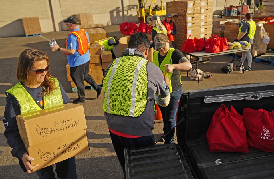 Volunteer Kari Hill loads food into vehicles during an annual Thanksgiving food distribution at St. Mary's Food Bank on Nov. 22, 2022.