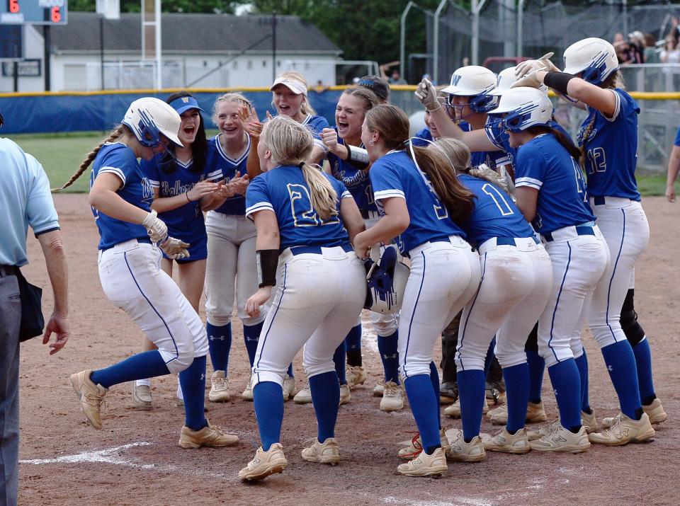 Walkersville's Izzy Dietrich is greeted by teammates at home plate after hitting a grand slam during the Lions' 9-6 win over Boonsboro in the CMC Small School softball championship game.
