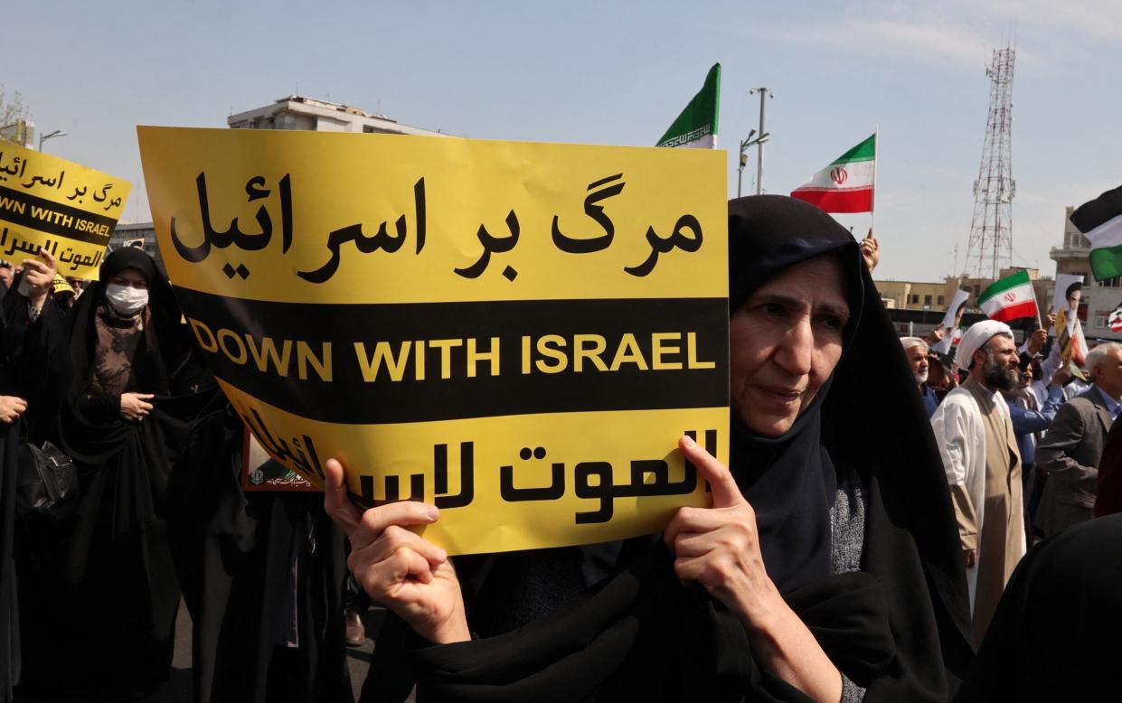 Iranians waved the flag of Palestine alongside their own country's in a demonstration against Israel in Tehran on Friday