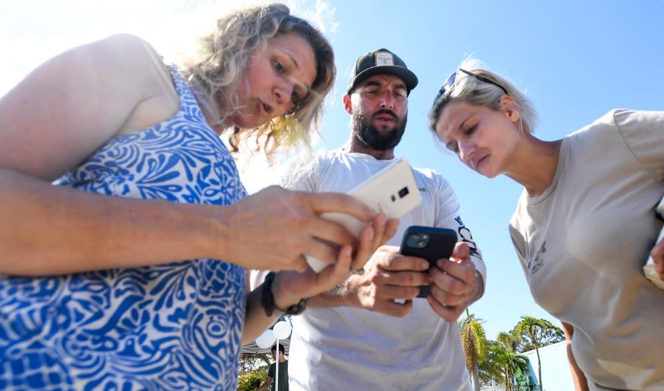 R2C2 volunteer Stephen Kantarze, center, confers with locals on where people need help on Pine Island near Fort Myers, Fla., on Wednesday, Oct. 5, 2022.