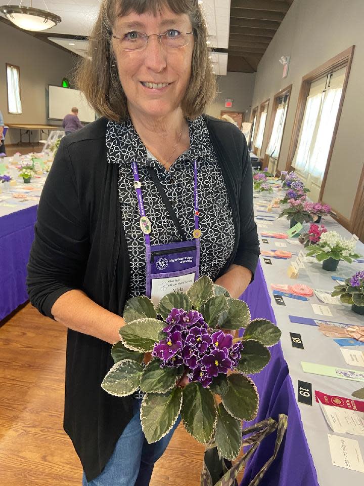 Vicki Ferguson proudly holds one of her 40 winning plants entered in the African Violet Society show at Kingwood Center Gardens last September.