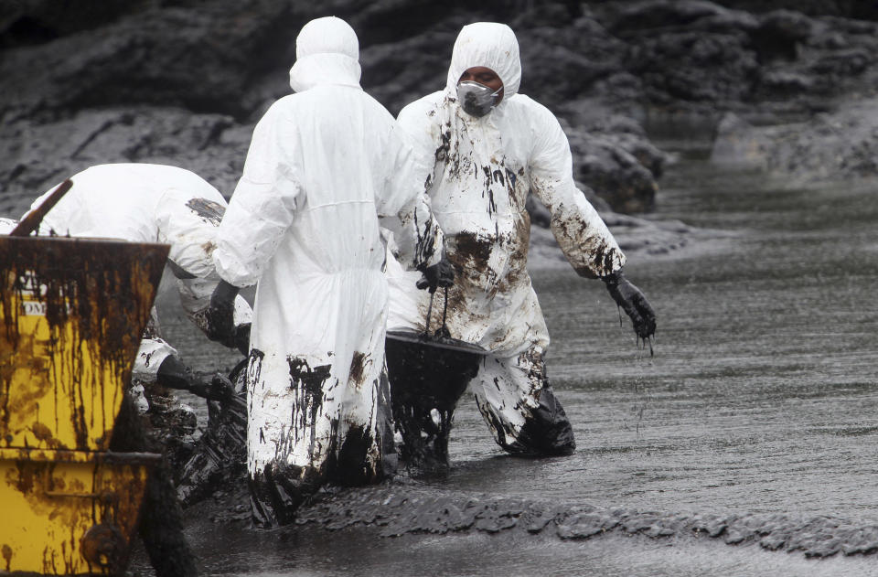 Workers remove crude oil during a clean up operation on the beach of Prao Bay on Samet Island in Rayong province eastern Thailand Tuesday, July 30, 2013. About 50,000 liters (13,200 gallons) of crude oil that leaked from a pipeline operated by PTT Global Chemical Plc, has reached the popular tourist island in Thailand's eastern sea despite continuous attempts to clean it up. (AP Photo)