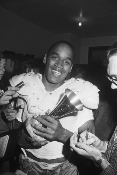 USC running back O.J. Simpson smiles as he holds the Player of the Game trophy following the 1967 Rose Bowl.