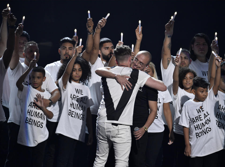 Ryan Tedder de One Republic, a la izquierda, y Logic se abrazan tras interpretar "One Day" en la ceremonia de los Premios MTV a los Videos Musicales, acompañados por inmigrantes, el lunes 20 de agosto del 2018 en el Radio City Music Hall en Nueva York. (Foto por Chris Pizzello/Invision/AP)