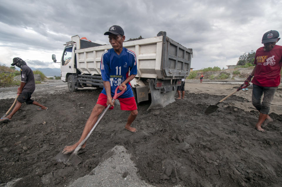 Workers shovel a mixture of sand and gravel onto trucks in the people's sand mining Palupi village, Palu, Central Sulawesi, Indonesia, February 24, 2019. Hundreds of people around the watershed depend on mining. Source: Basri Marzuki/NurPhoto via Getty Images.